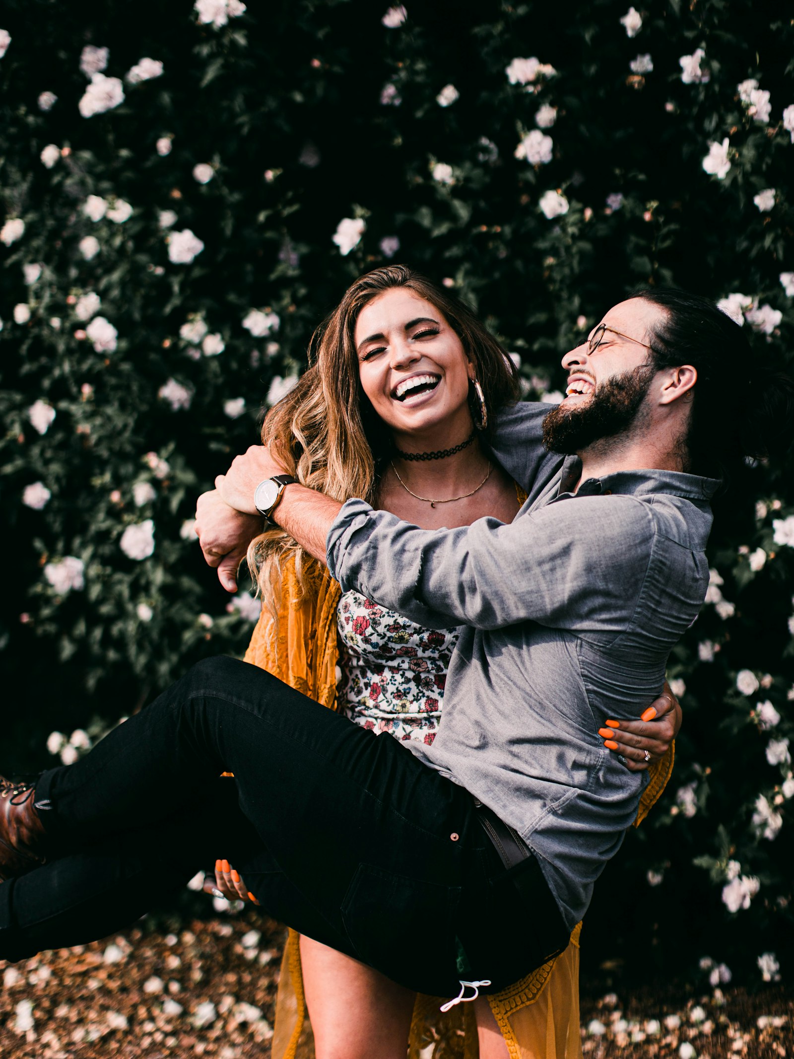 A couple laughing under blossom