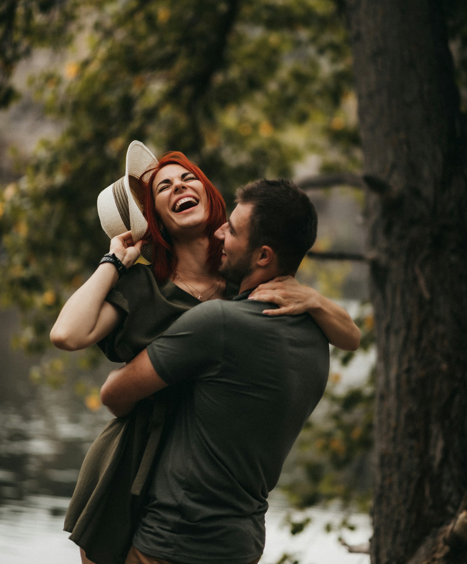 A couple laughing, one lifting the other